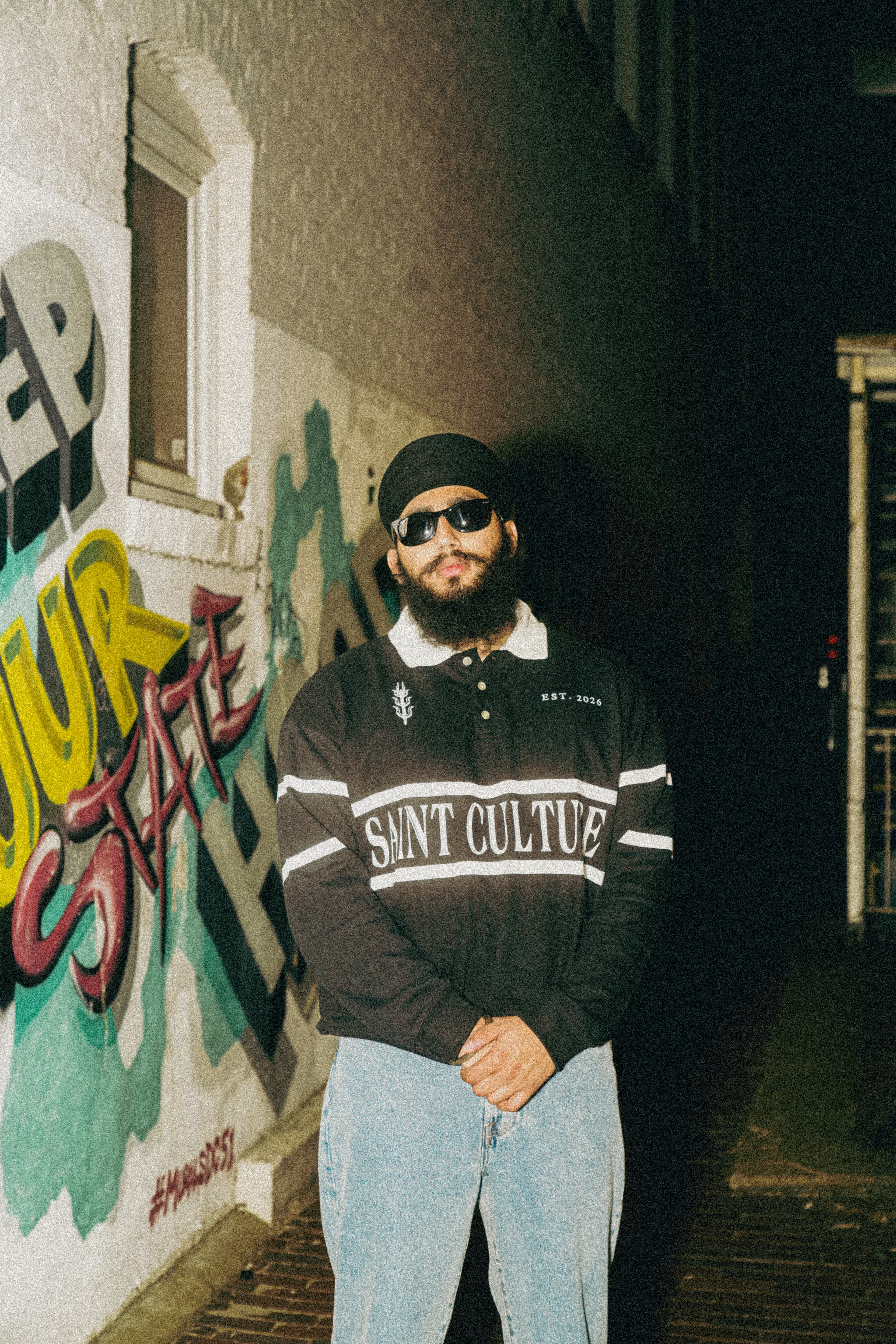 Model wearing the SAINT CULTURE polo — campaign shot.